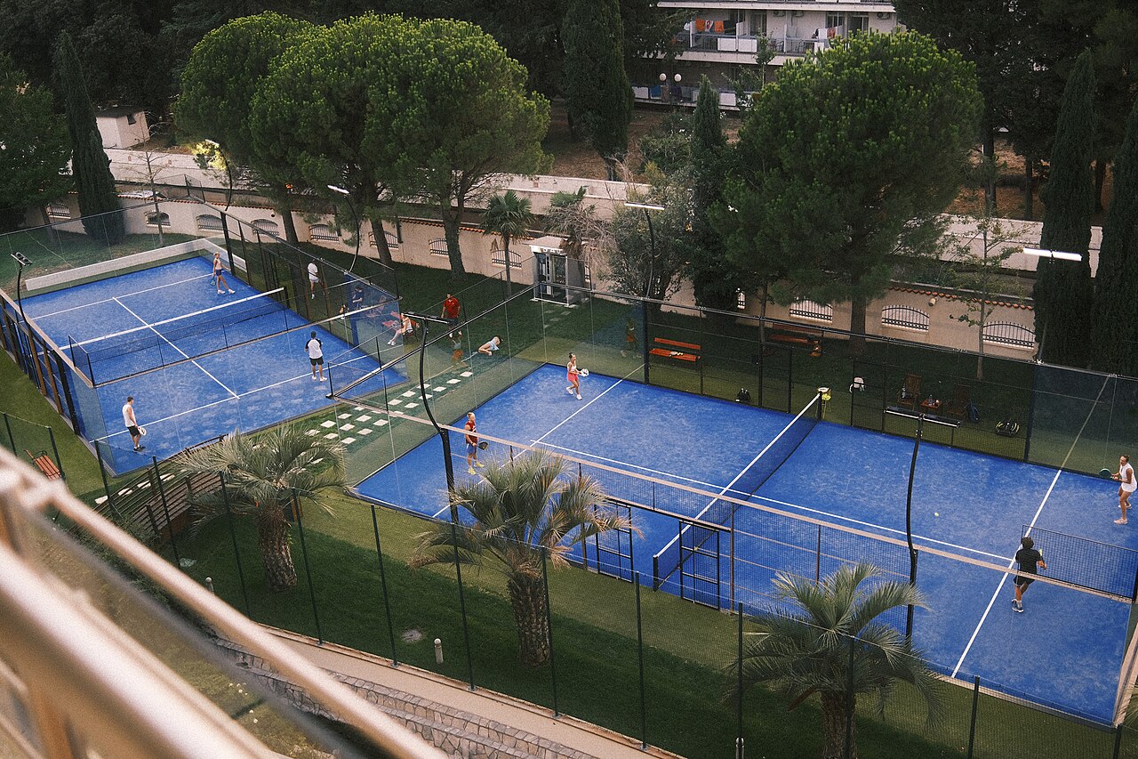 FairPlay Tennis Doubles: a doubles pair covering the net during a floodlit match